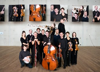 members of the Ives Ensemble grouped against photos of the photo